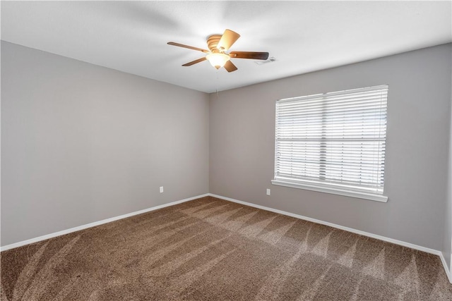 spare room with baseboards, visible vents, carpet floors, and ceiling fan