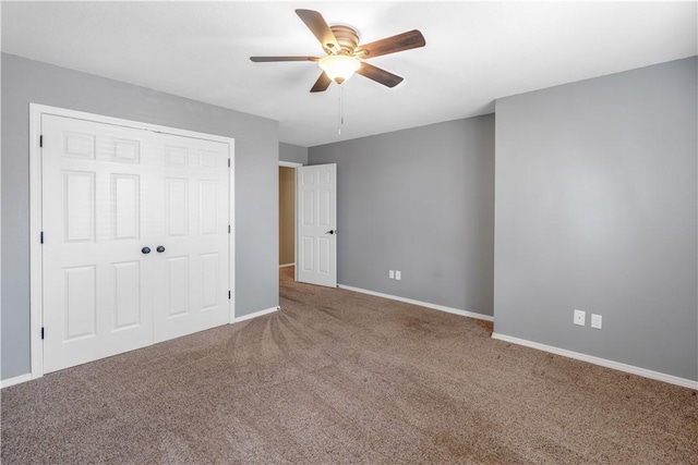 unfurnished bedroom with a ceiling fan, carpet flooring, baseboards, and a closet