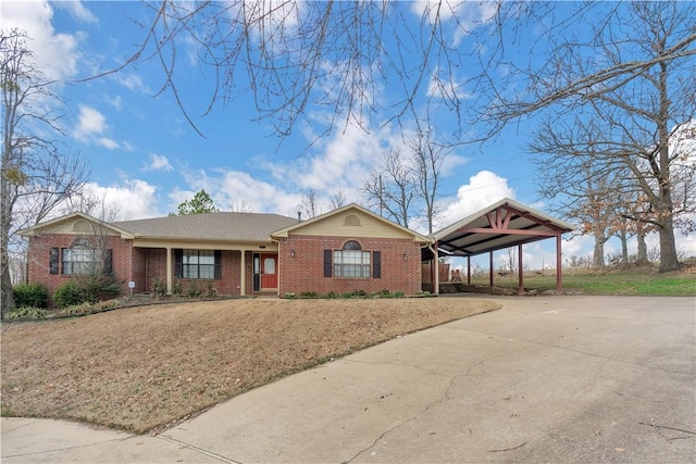 ranch-style house featuring concrete driveway, a carport, and brick siding