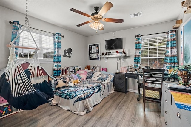 bedroom featuring ceiling fan, visible vents, and wood finished floors