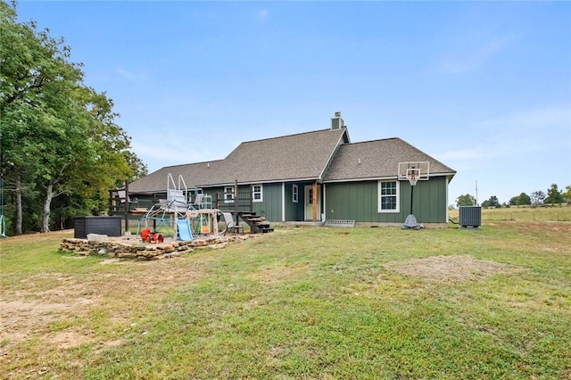 rear view of house featuring a yard, central AC, and a chimney