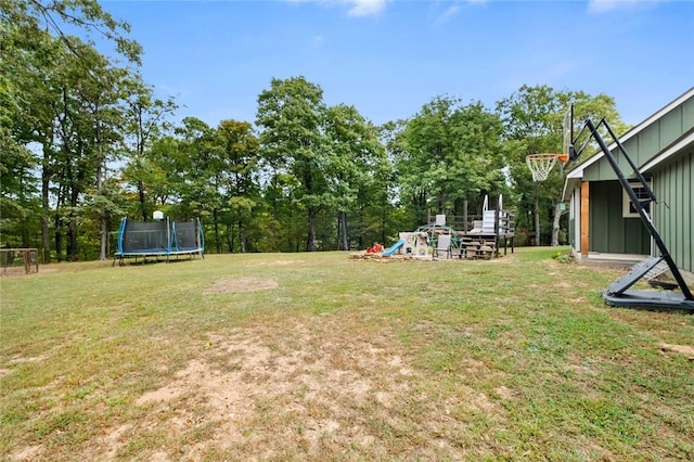 view of yard with a playground and a trampoline