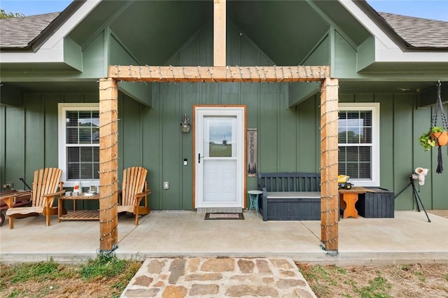 property entrance featuring a porch, board and batten siding, and roof with shingles