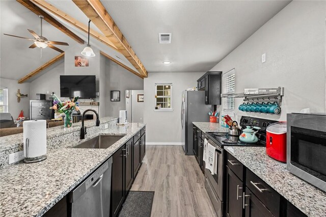 kitchen featuring visible vents, dark cabinets, appliances with stainless steel finishes, and a sink