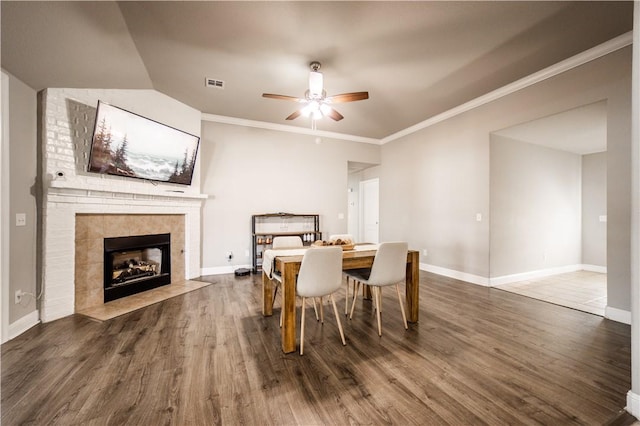 dining space featuring visible vents, crown molding, baseboards, and wood finished floors