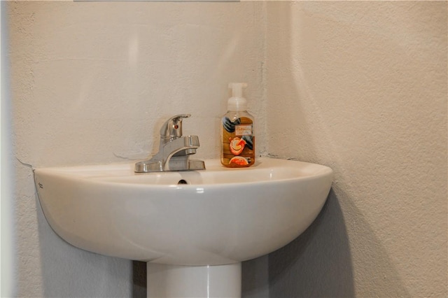 bathroom featuring a sink and a textured wall