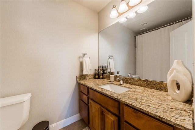 bathroom with tile patterned flooring, toilet, vanity, and baseboards