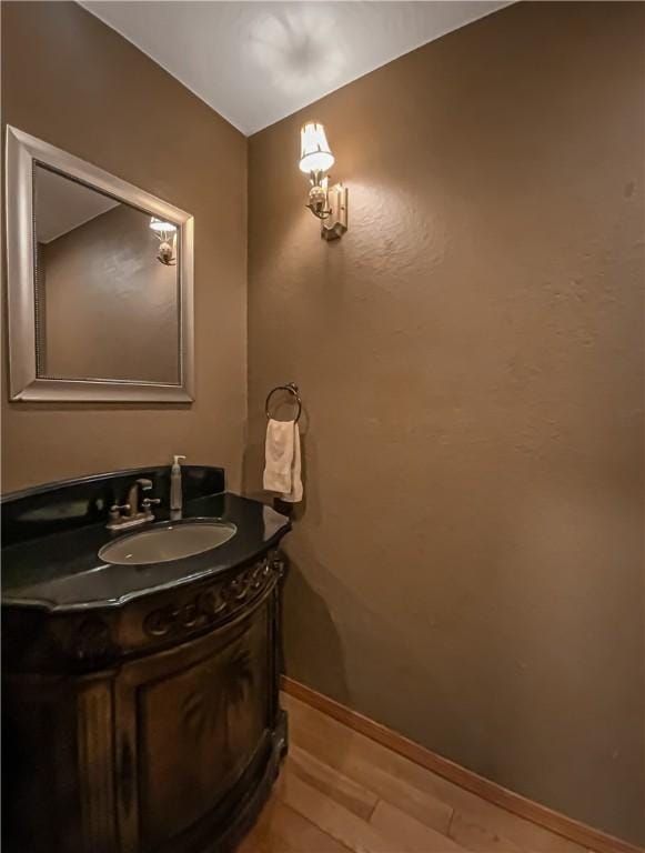 bathroom featuring vanity, baseboards, and wood finished floors