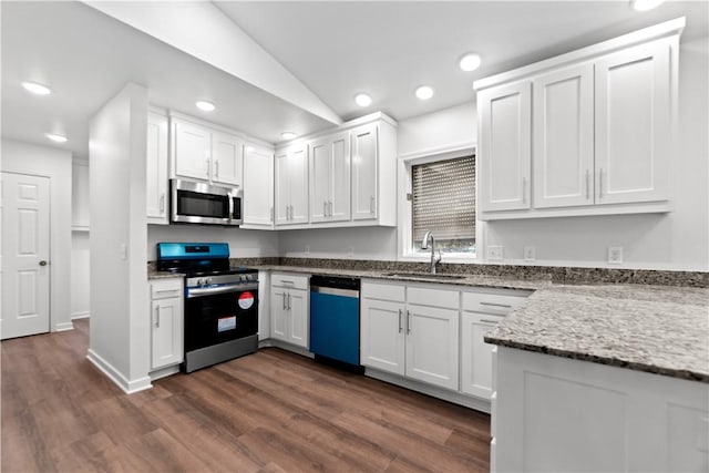 kitchen with dark wood finished floors, white cabinets, appliances with stainless steel finishes, and a sink