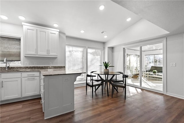 kitchen with a sink, dark wood-style floors, white cabinetry, recessed lighting, and lofted ceiling