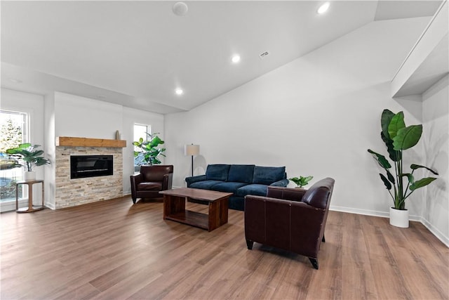 living area with wood finished floors, recessed lighting, a fireplace, baseboards, and vaulted ceiling