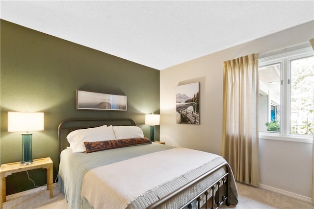 bedroom featuring light carpet and baseboards