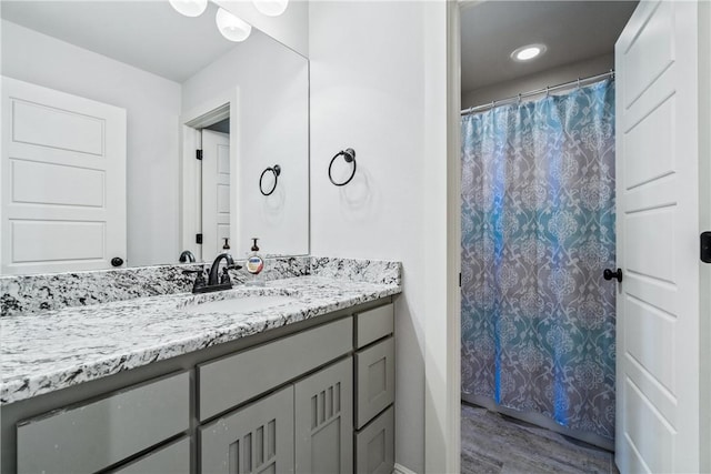 bathroom with vanity, a shower with shower curtain, and wood finished floors