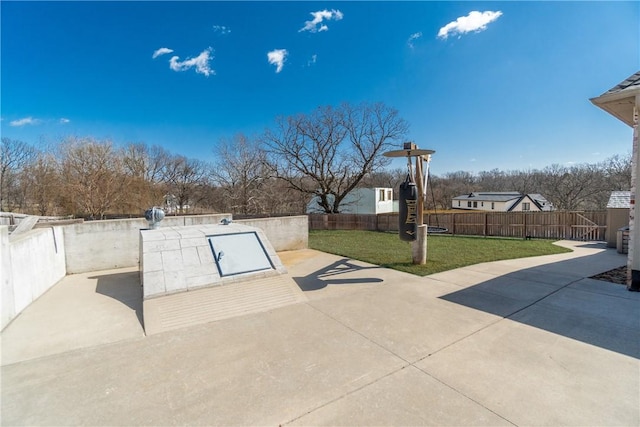 view of storm shelter with a patio area, fence, and a lawn