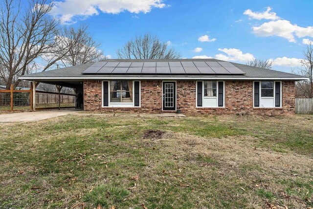 ranch-style house featuring fence, a carport, concrete driveway, a front lawn, and brick siding