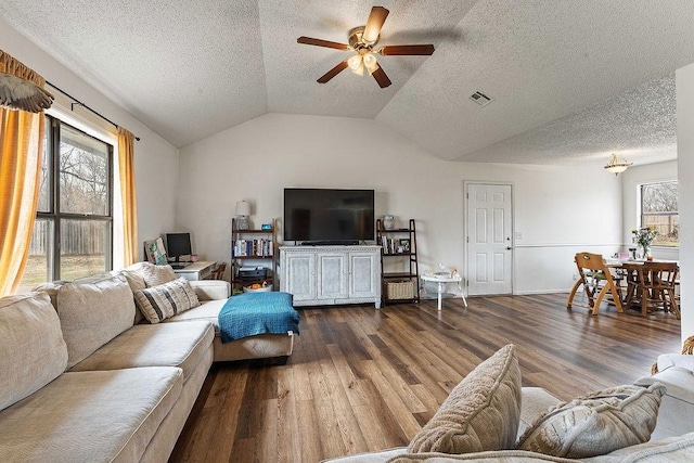 living room featuring visible vents, a healthy amount of sunlight, wood finished floors, and vaulted ceiling