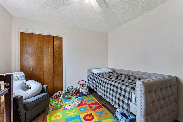 bedroom with a closet, a textured ceiling, and a ceiling fan