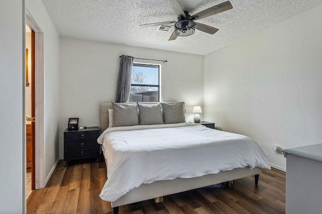 bedroom featuring baseboards, a textured ceiling, and wood finished floors