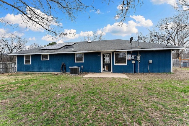 back of house with a patio, fence, solar panels, central AC, and a lawn