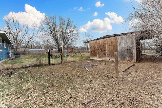 view of yard featuring an outdoor structure, a playground, and fence