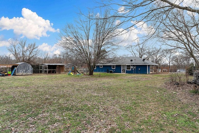 view of yard with a storage shed, an outdoor structure, and a playground