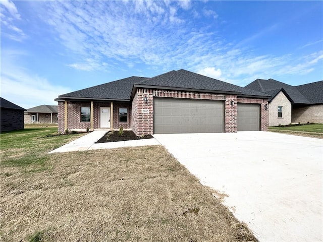 view of front of property with a front lawn, roof with shingles, concrete driveway, an attached garage, and brick siding