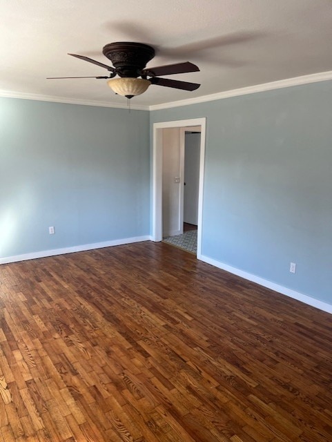 unfurnished room featuring dark wood finished floors, crown molding, and baseboards