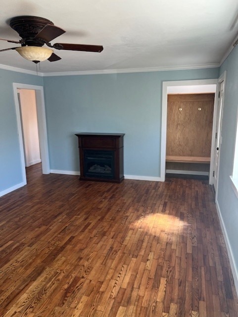 unfurnished living room featuring dark wood-style floors, a fireplace, baseboards, and ornamental molding