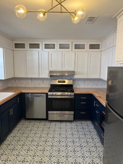 kitchen with visible vents, under cabinet range hood, appliances with stainless steel finishes, white cabinetry, and blue cabinets