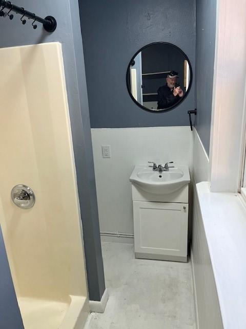 bathroom featuring vanity, a shower stall, and concrete floors