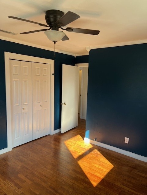 unfurnished bedroom with a ceiling fan, wood finished floors, visible vents, and baseboards