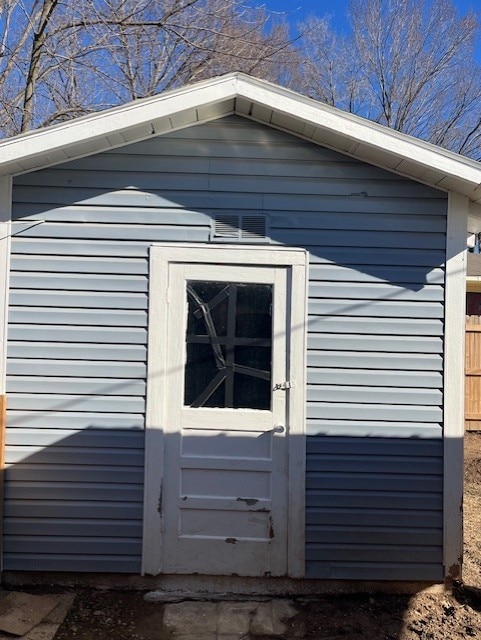 view of property exterior with an outbuilding, a storage unit, and fence