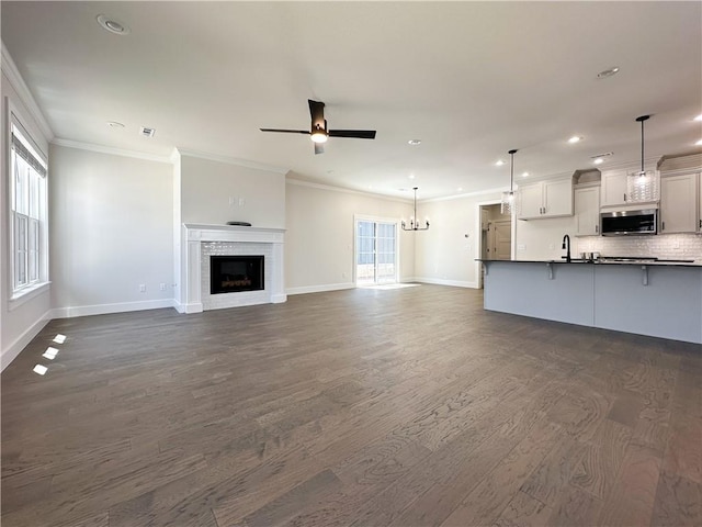 4412 W Bronco Dr, Fayetteville, AR 72704 - unfurnished living room with a ceiling fan, recessed lighting, dark wood-type flooring, crown molding, and a brick fireplace