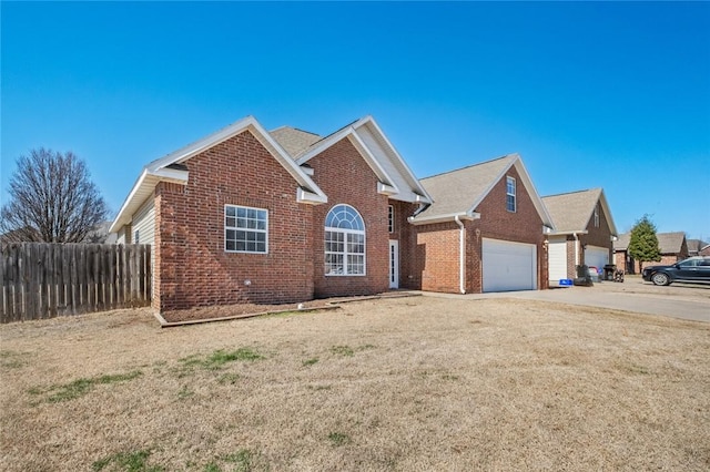 ranch-style home featuring a front yard, brick siding, driveway, and fence