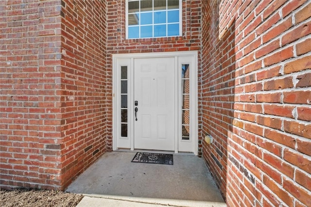 property entrance featuring brick siding