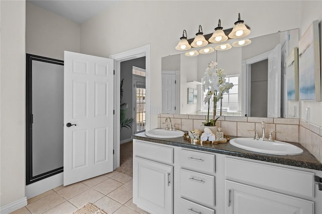 bathroom featuring tile patterned floors, double vanity, tasteful backsplash, and a sink