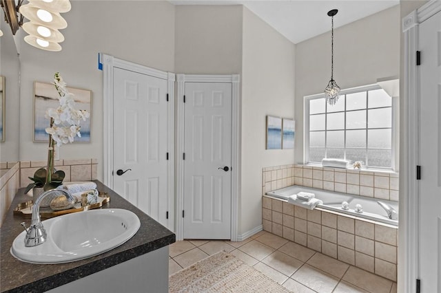 bathroom featuring tile patterned floors, a garden tub, and vanity