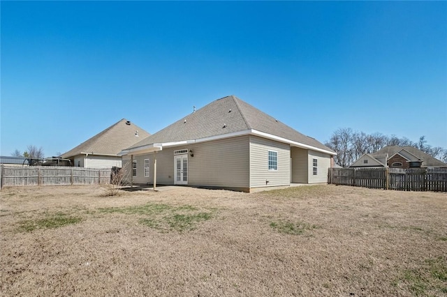 rear view of property with french doors, a yard, and a fenced backyard