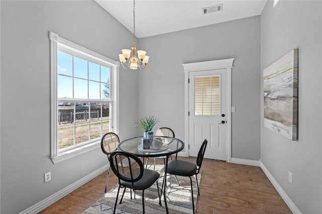 dining area with a chandelier, visible vents, baseboards, and wood finished floors