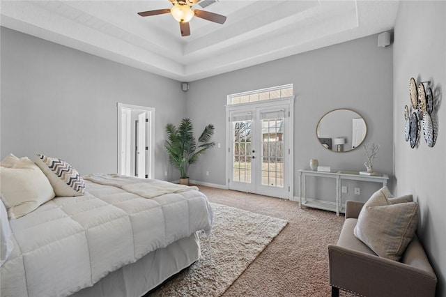 bedroom with carpet, a tray ceiling, a high ceiling, french doors, and access to outside