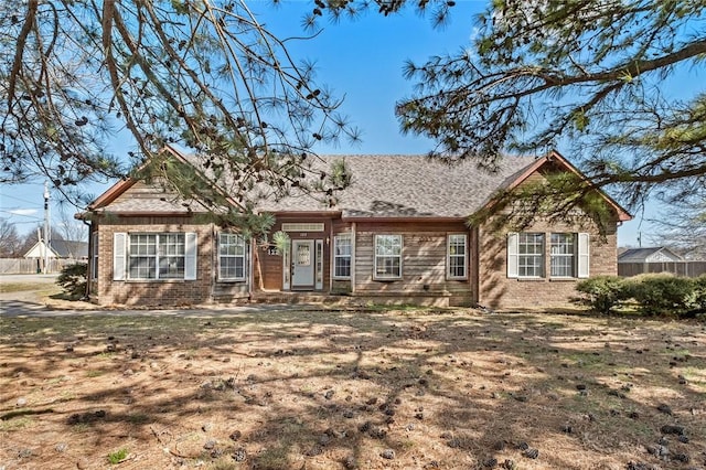 view of front of property with brick siding and fence