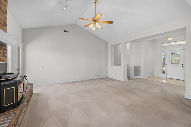 living area featuring visible vents, light carpet, and vaulted ceiling