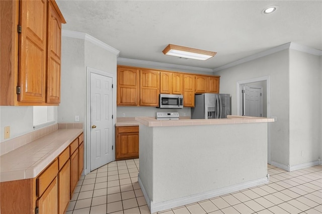 kitchen with tile counters, light tile patterned floors, appliances with stainless steel finishes, and ornamental molding