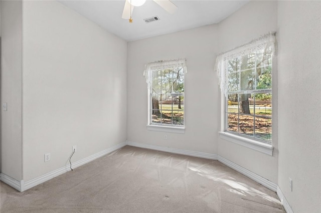 carpeted spare room with baseboards, visible vents, and a wealth of natural light