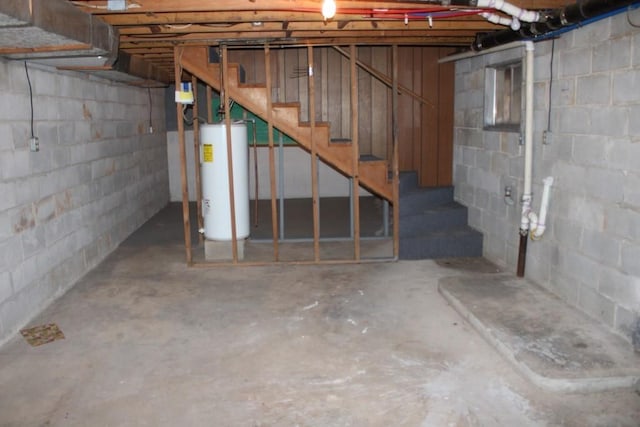 unfinished basement featuring stairway and gas water heater