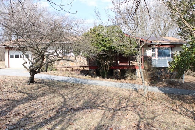 view of property hidden behind natural elements with a garage