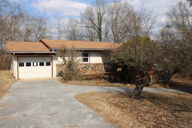 view of front of home featuring aphalt driveway, stone siding, and an attached garage