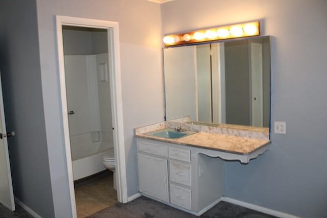 full bathroom with baseboards, toilet, and vanity