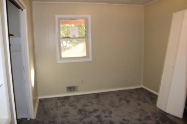 carpeted spare room featuring visible vents and baseboards