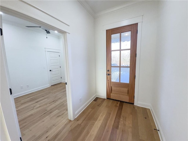 doorway featuring light wood-style floors, baseboards, and ornamental molding